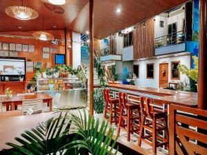 a restaurant with a bar with chairs and plants at RedDoorz at Balai Malinawon Siargao in General Luna