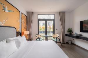 a bedroom with a bed and a table and a window at AviCasa T21 in Gò Công