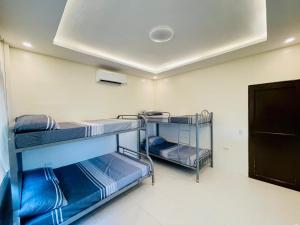 a room with three bunk beds and a ceiling at Camp J Staycation in Cayucay +1 photo