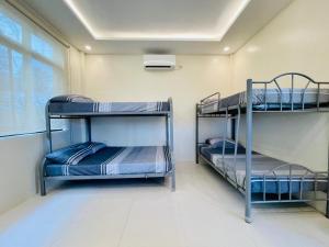 two bunk beds in a room with a window at Camp J Staycation in Cayucay