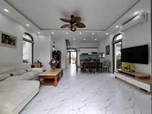 a living room with a couch and a flat screen tv at V3L05-Sonasea Vân Đồn in Thâm Câu