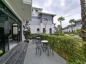 a patio with chairs and a table in front of a building at V3L05-Sonasea Vân Đồn in Thâm Câu