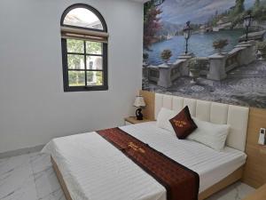 a bedroom with a large bed with a painting on the wall at V3L05-Sonasea Vân Đồn in Thâm Câu