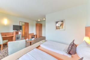 a hotel room with two beds and a tv at ateckhotel Kirchheim/Teck in Kirchheim unter Teck