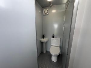 a small bathroom with a toilet and a sink at Seaview Cabin in Tapu