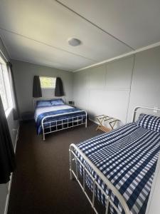 a bedroom with two beds in a room at Seaview Cabin in Tapu
