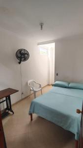 a bedroom with a bed and a table and a chair at Hotel Real Caracoli in Guamal