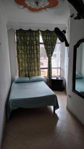 a bedroom with a bed in front of a window at Hotel Real Caracoli in Guamal