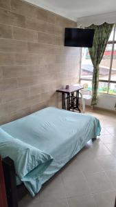 a bedroom with a bed and a table and a window at Hotel Real Caracoli in Guamal