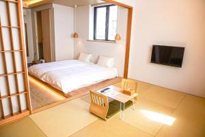 a bedroom with a bed and a table and a tv at Hotel Imagine Kyoto in Kyoto +73 photos