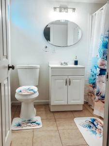 a bathroom with a toilet and a sink and a mirror at Saffire Villa Rooms in Tacoma