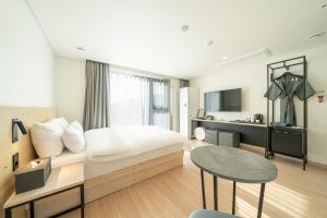 ein Hotelzimmer mit einem Bett und einem Tisch in der Unterkunft hotel J bay in Samgong-ni