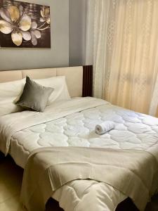 a large white bed with two towels on it at Compound Porto New Cairo in Cairo