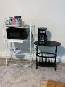 a microwave sitting on a shelf next to a table at Saffire Villa Rooms in Tacoma