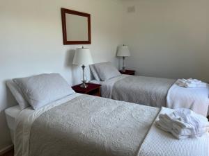 two beds in a hotel room with towels on them at The Ginger Bread House in Mount Beauty
