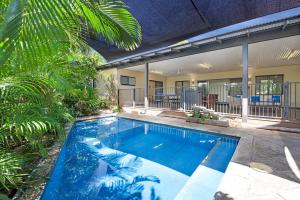 a swimming pool in front of a house at Balu luxe in Broome