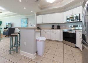 a large kitchen with white cabinets and a counter top at Phoenix West 708 in Orange Beach
