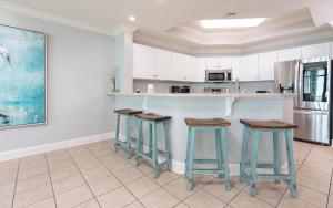 a kitchen with blue stools and a counter at Phoenix West 708 in Orange Beach