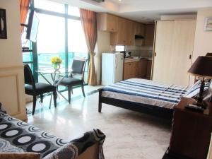 ein Schlafzimmer mit Bett und Tisch und eine Küche in der Unterkunft Baywatch Tower in Manila