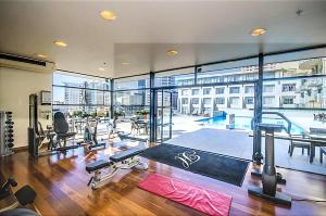 a gym with a large window and a gym with tread machines at Sky Tower Studio - Pools, Spa, Gym & Super King in Auckland