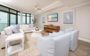 a living room with white furniture and windows at Phoenix West 2008 in Orange Beach