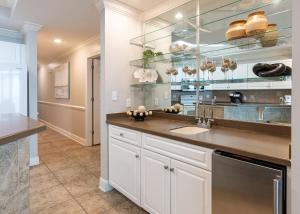 a kitchen with a sink and glass shelves at Phoenix West 2008 in Orange Beach