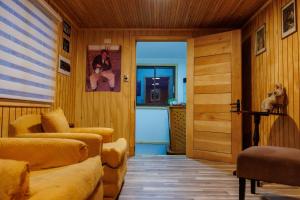 a living room with wood paneled walls and a door at Hostal Royal Austral in Coihaique