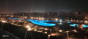 a large swimming pool at night with lights at chalet - Plumar El Sokhna in Ain Sokhna