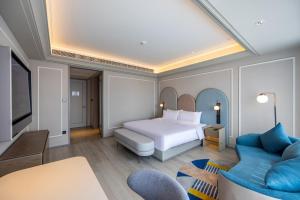 a hotel room with a bed and a couch at Mercure Tianshui Downtown in Tianshui