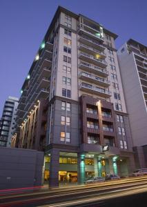 a tall building with cars parked in front of it at Sky Tower Studio - Pools, Spa, Gym & Super King in Auckland