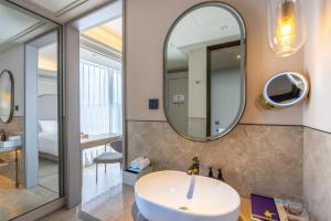 a bathroom with a sink and a mirror at Mercure Tianshui Downtown in Tianshui +59 photos