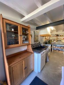 a large kitchen with wooden cabinets and a sink at le relais Perrusson, Bed and breakfast et camping à la tuilerie in Écuisses