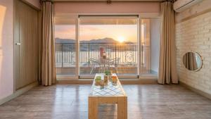 a living room with a table and a large window at tongyeong haegando pension in Tongyeong