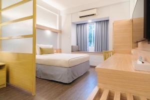 a bedroom with a bunk bed and a desk at Microtel by Wyndham Batangas in Santo Tomas +34 photos