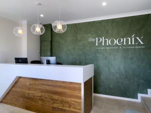 an office with a reception desk with a green wall at The Phoenix Artesian Spa Resort and Accommodation in Moree +34 photos