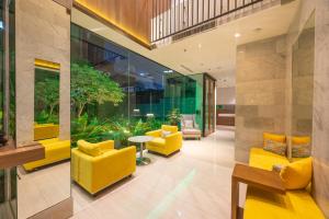 a lobby with yellow chairs and a table at LiT BANGKOK Residence in Bangkok