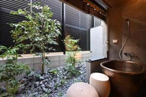 a bathroom with a tub and a tree in a garden at Kiyomizu Elite Terrace in Kyoto