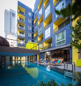 a swimming pool in front of a building at LiT BANGKOK Residence in Bangkok