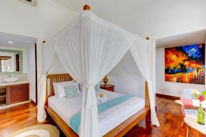 a bedroom with a bed with a canopy at Olala Suite Canggu Guesthouse in Canggu