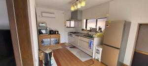 a small kitchen with a refrigerator and a sink at Suzume no oyado SO1 in Shima