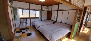 a small bedroom with two beds and a window at Suzume no oyado SO1 in Shima