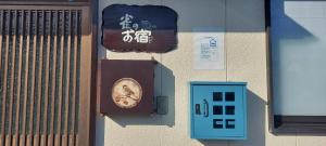a sign on the side of a building with a clock at Suzume no oyado SO1 in Shima