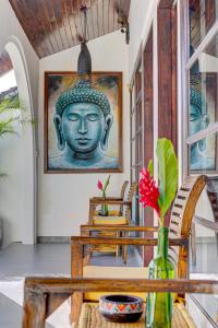 a dining room with a statue of a head on the wall at Olala Suite Canggu Guesthouse in Canggu