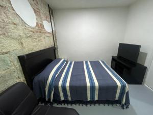 a bedroom with a bed and a television in it at Casa Rayon Oaxaca in Oaxaca City