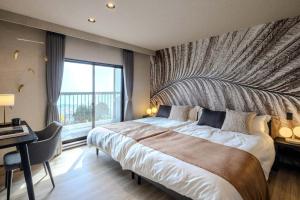 a bedroom with a large bed with a large window at KomoreNest伊豆熱川 in Higashiizu