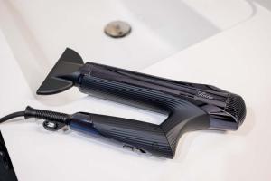 a black hair dryer sitting on a white table at KomoreNest伊豆熱川 in Higashiizu