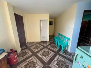 a room with blue chairs and a tile floor at Rjoyz transient house in Itogon