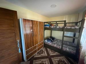 a room with two bunk beds and a door at Rjoyz transient house in Itogon