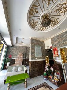 a living room with a green bench and a ceiling at King hotel in Dĩ An