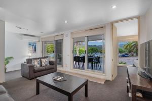 a living room with a couch and a table at Esplanade Apartments in Whitianga